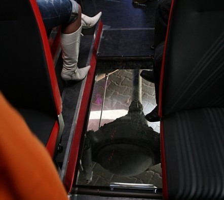 Viens no autobusiem caur drošu stiklu ļauj novērot autobusa aizmugurējā tilta darbību un bedrainās ielas 21951