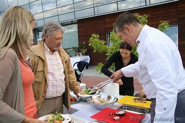 Ingmārs Ladigs pasniedz ēdienu pasākuma viesiem 34358