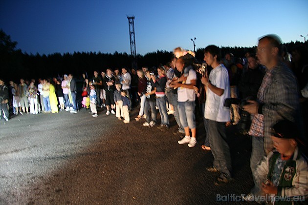 Apbalvošānas ceremonija nakts tumsā un auto lukturu gaismā 35798