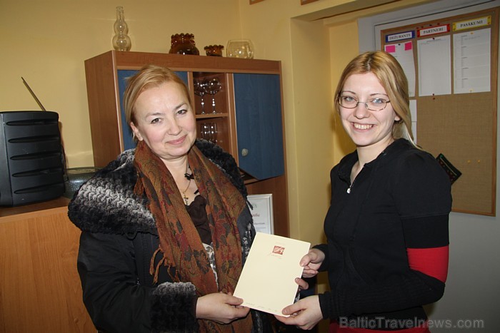 Travelnews.lv redaktore Kristīne Indriksone (no labās) pasniedz Elvirai Jakobsonei dāvanu karti luksa numuram dizaina viesnīcā Ainavas 55866