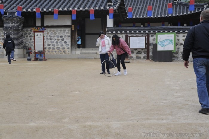 Korejieši mēģina uzspēlēt spēli ar bumbu un maziem irbulīšiem - Hoop Rolling - www.traveltime.lv 89599